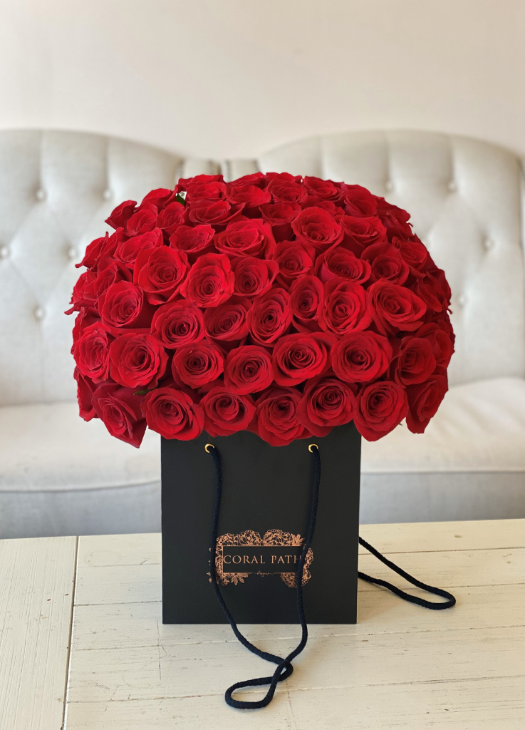 Red roses arranged in bag shaped box.