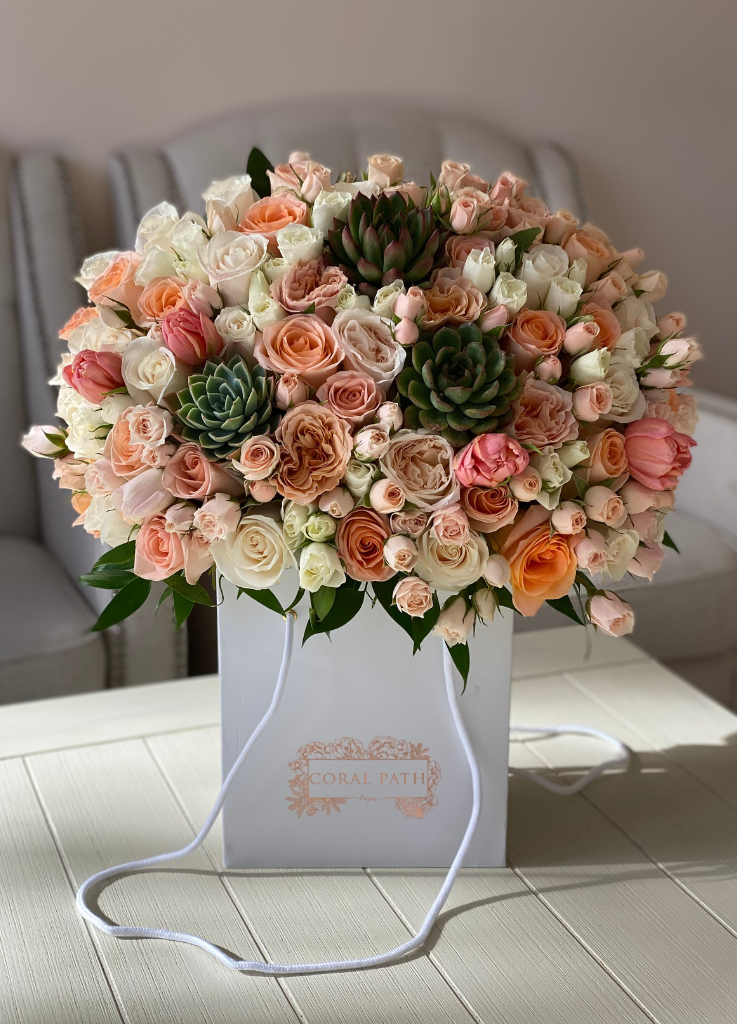 Succulents with peach colored roses and spray roses