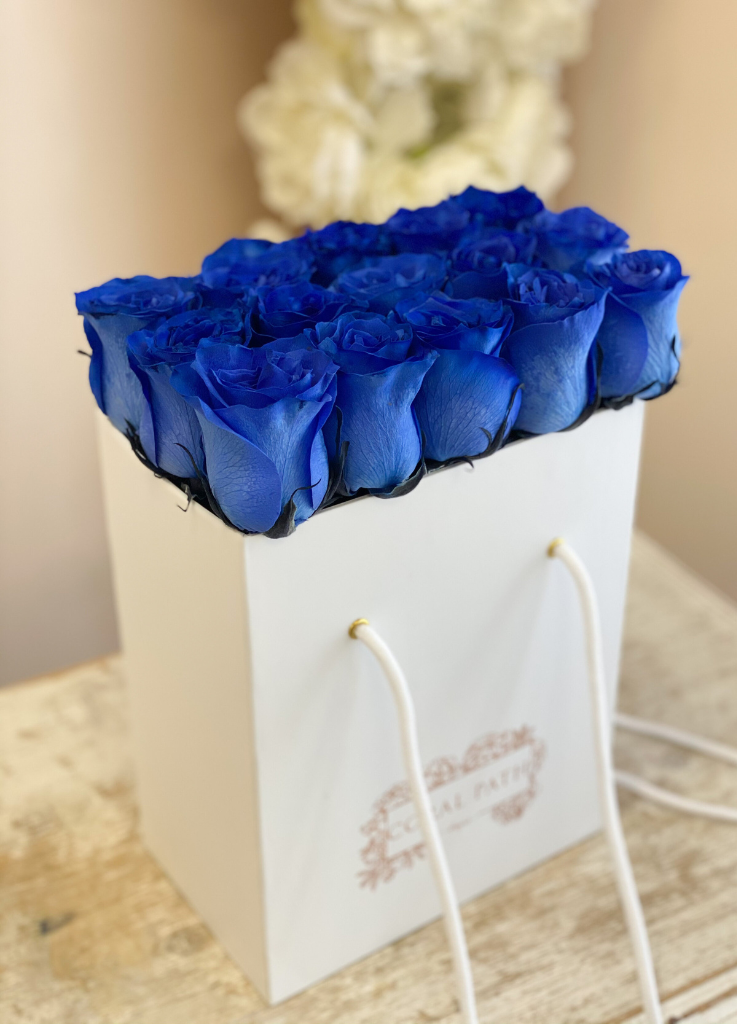 Fresh blue roses neatly arranged in a flower bag.