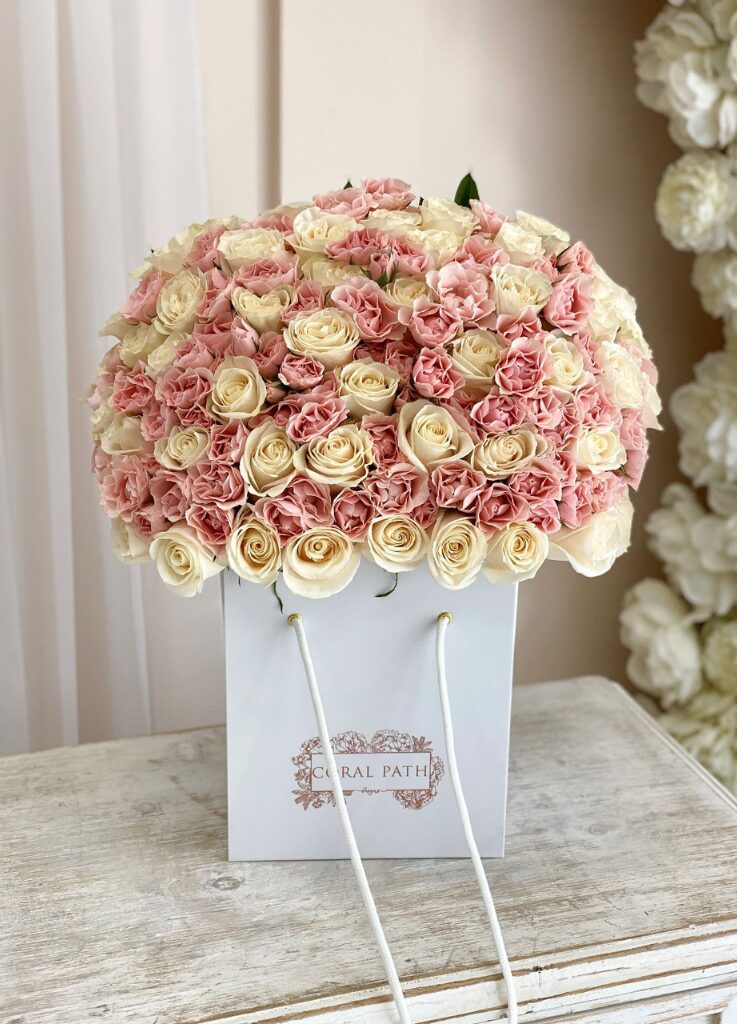 Blush pink Majolika spray roses and ivory Vendela roses mixed in a flower bag.