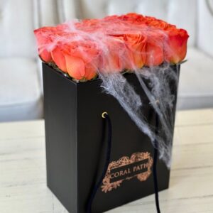 Orange roses neatly arranged in a box, with spider webs for Halloween
