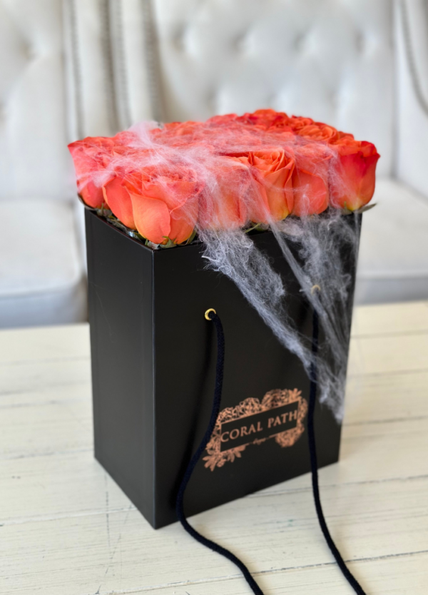 Orange roses neatly arranged in a box, with spider webs for Halloween
