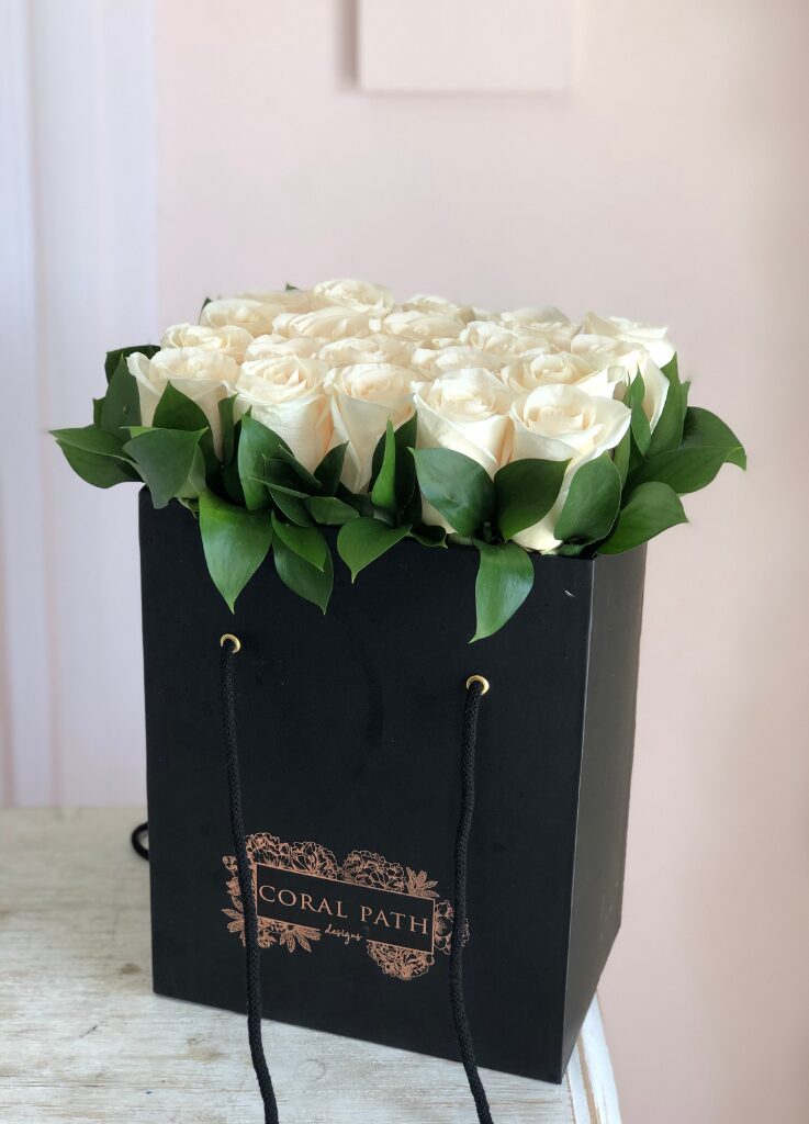 Ivory roses neatly arranged in a flower bag.