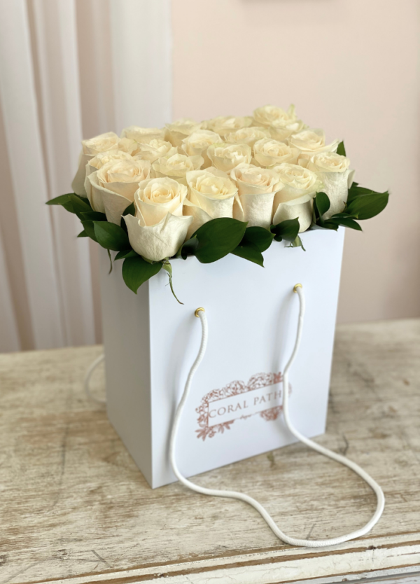 Ivory roses neatly arranged in a flower bag.
