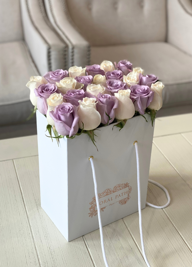 Lavender and ivory roses in a flower bag.