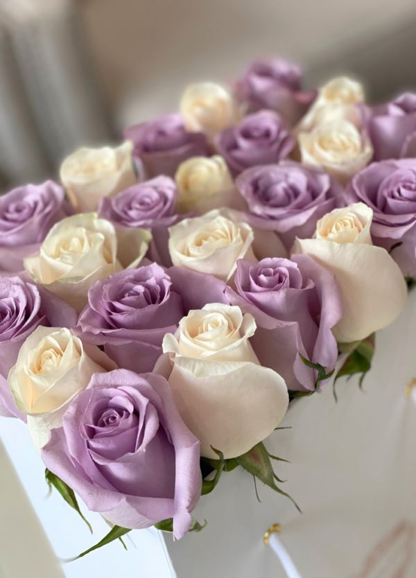 Lavender and ivory roses in a flower bag.