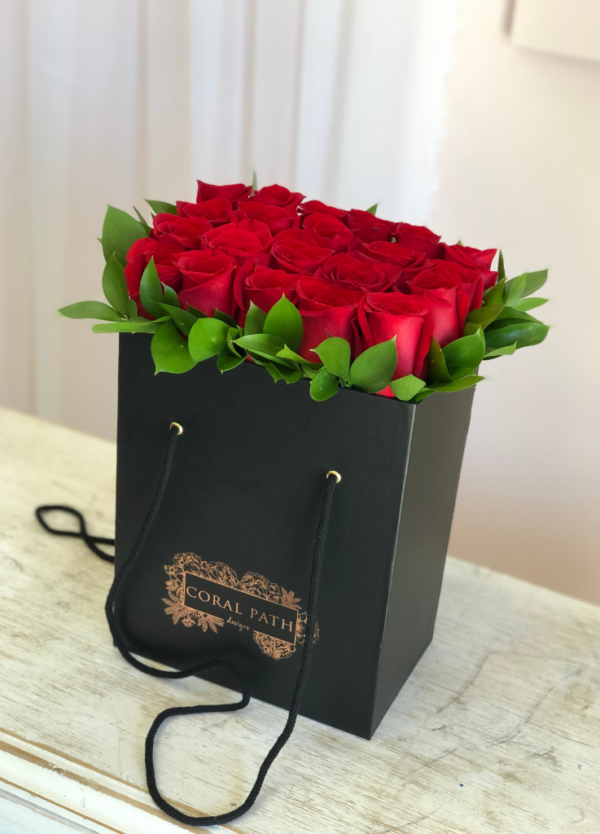 Red roses neatly arranged in a black bag box from Coral Path
