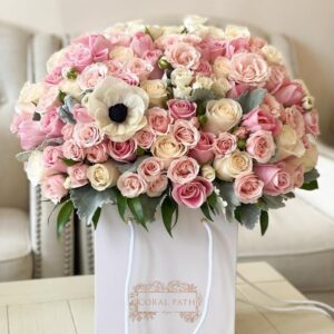A dusty color blend of roses, anemones, duty miller leaves all arranged in a bag.
