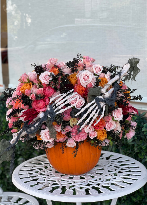 Halloween arrangement on a real pumpkin with skeleton bones.