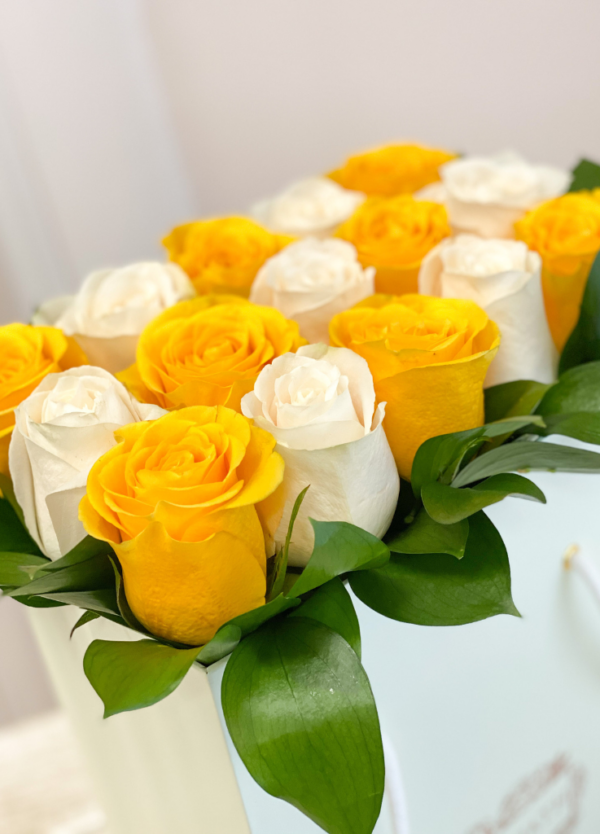 Yellow and white roses neatly arranged in a flower bag.