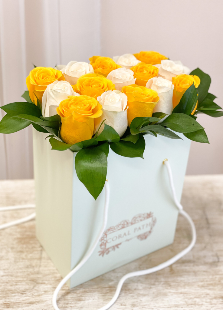 Yellow and white roses neatly arranged in a flower bag.