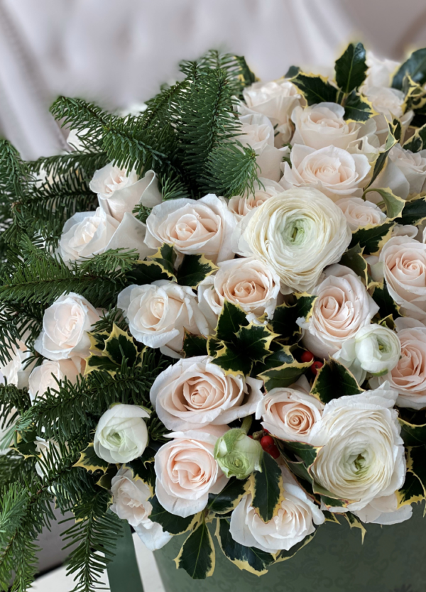 "Image description: Winter floral arrangement with white roses and ranunculus, evoking a serene winter landscape in the Holiday Collection.