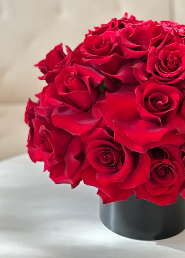 Charming red roses arranged in a black vase perfect for a centerpiece.