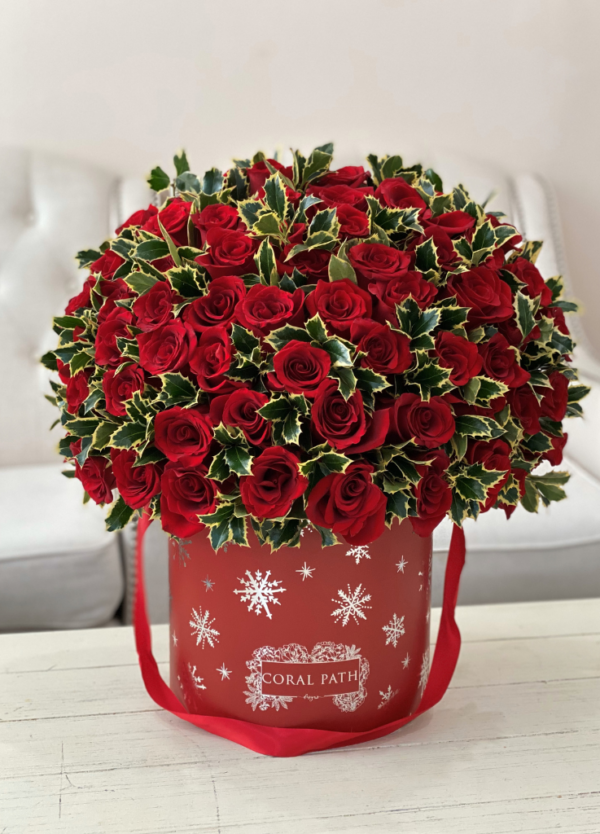 Image description: Exclusive Christmas box with red roses, holly greenery, and silver snowflakes, bringing warmth and festivity to the holidays."