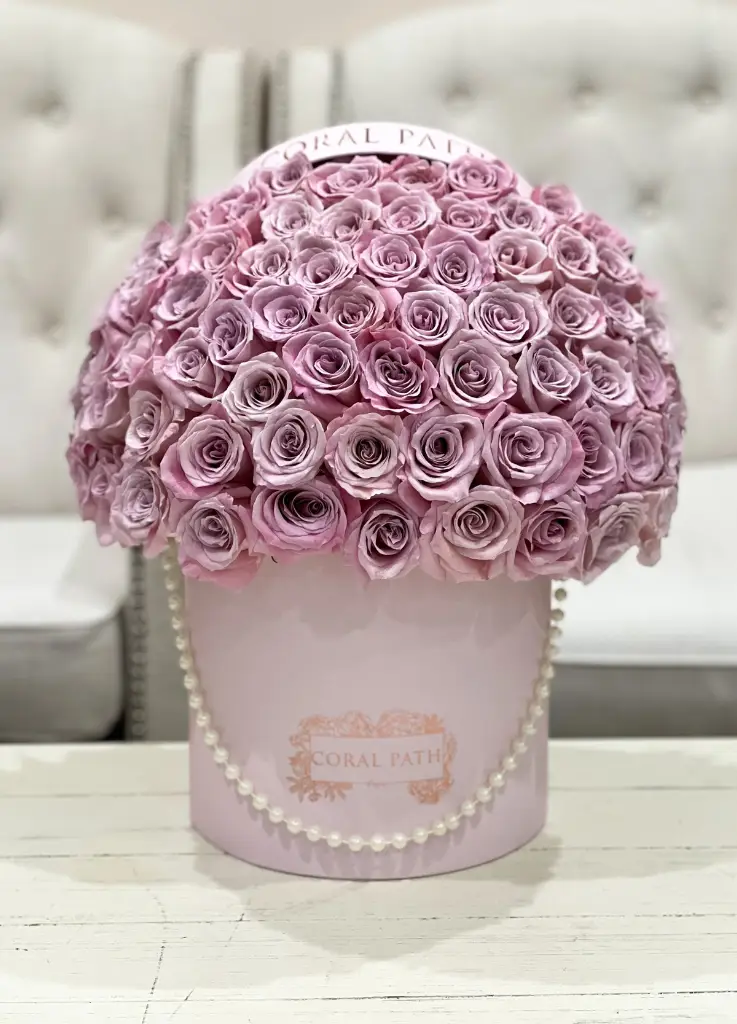Faith roses arranged in a hat box with pearl handle.