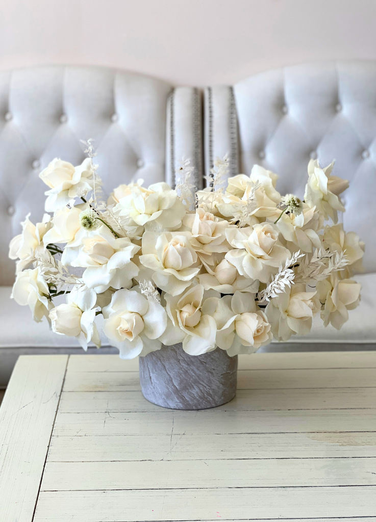 Image description: Luxurious 'Flaire' flower arrangement with reflexed white dove roses forming an elegant angel-wing shape, ideal for various occasions.
