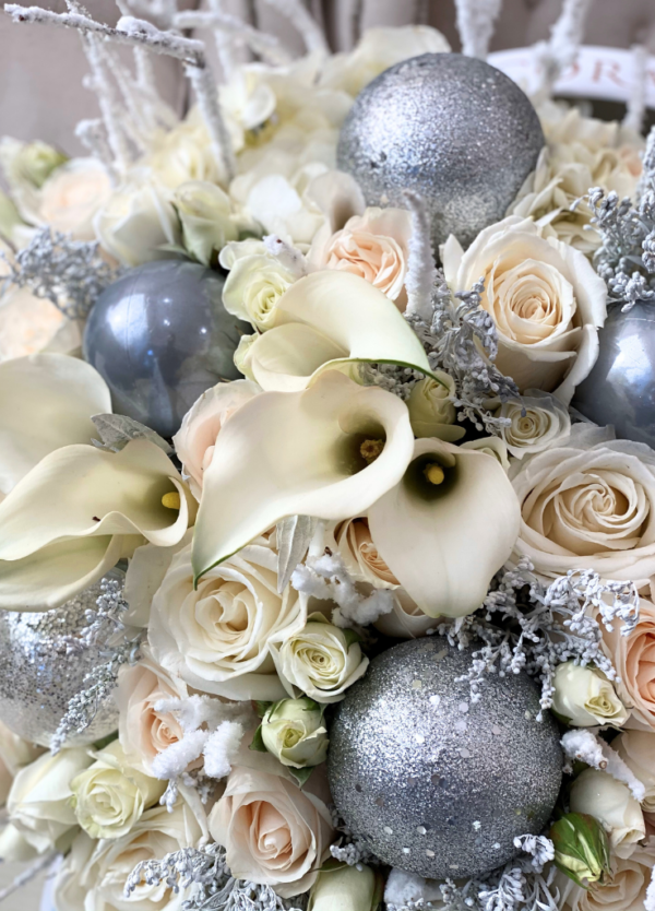 Silver Frost Arrangement by Coral Path: a festive mix of snowy branches, white roses, and silver ornaments. Available for delivery or pick up.