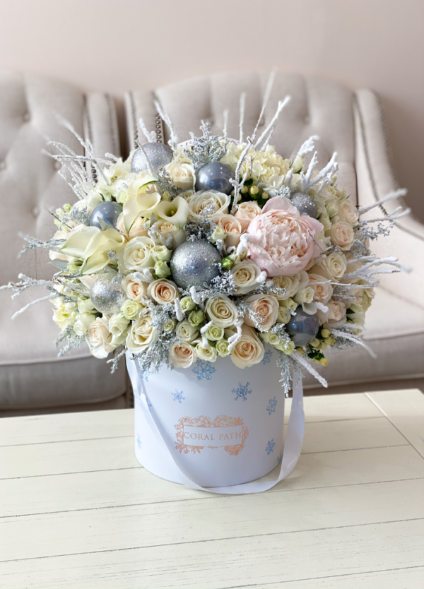 Silver Frost Arrangement by Coral Path: a festive mix of snowy branches, white roses, and silver ornaments. Available for delivery or pick up.