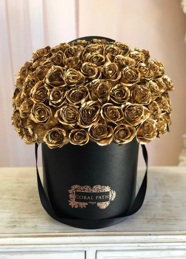 Gold rose bouquet arranged in a hat box.