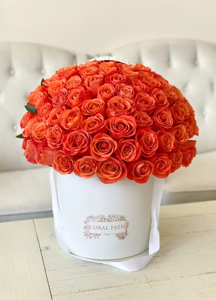 Orange roses arranged in a hat box.