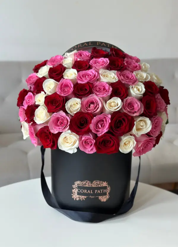 Red, pink, white roses arranged in a hat box.