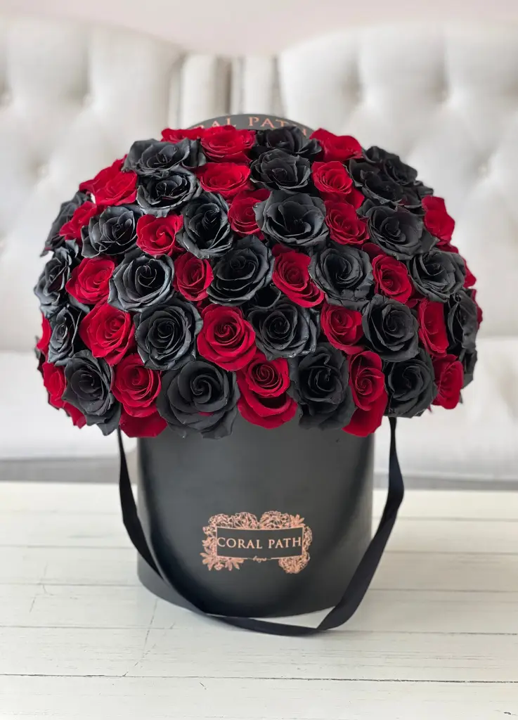 Red and black roses in a hat box.