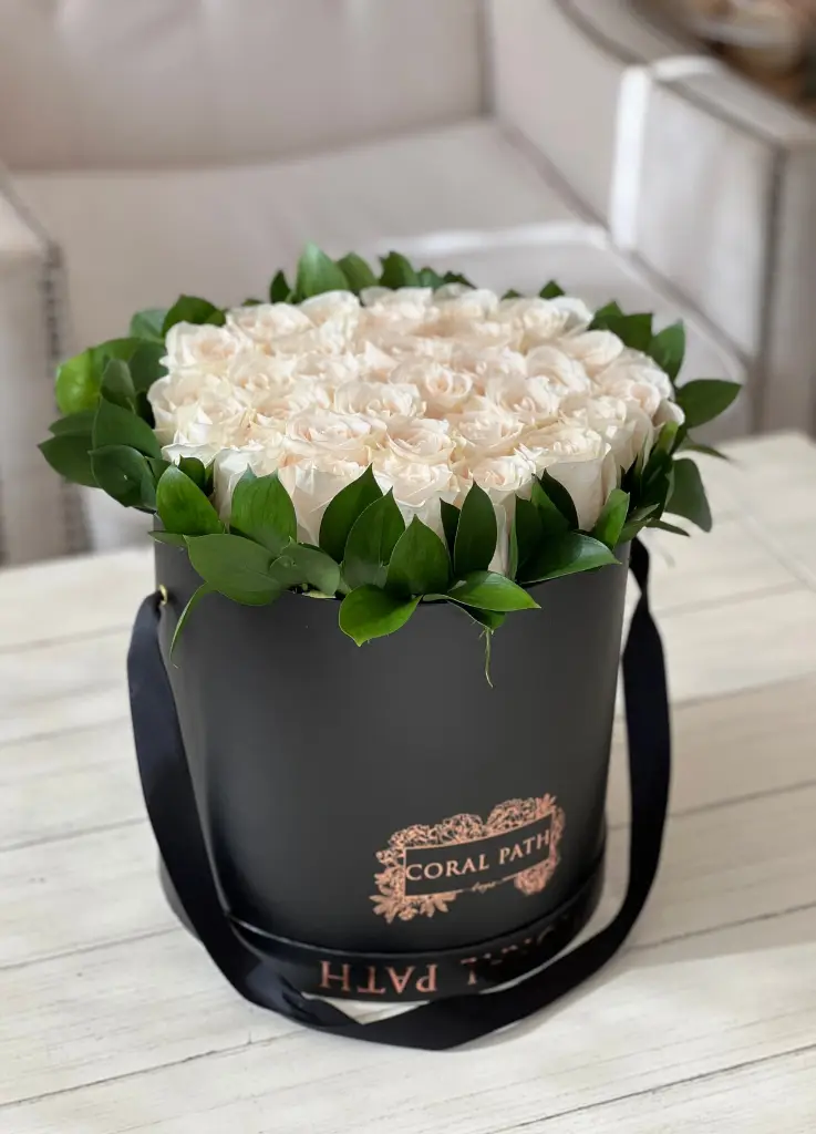 Ivory roses arranged in a hat box.