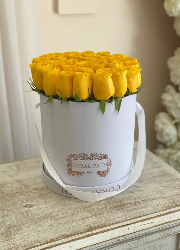 Yellow roses arranged in a hat box.