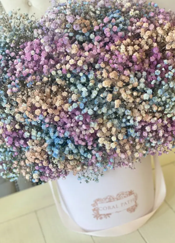 Baby's breath flowers in lavender, teal and blush pink mixed up in a hat box arrangement.