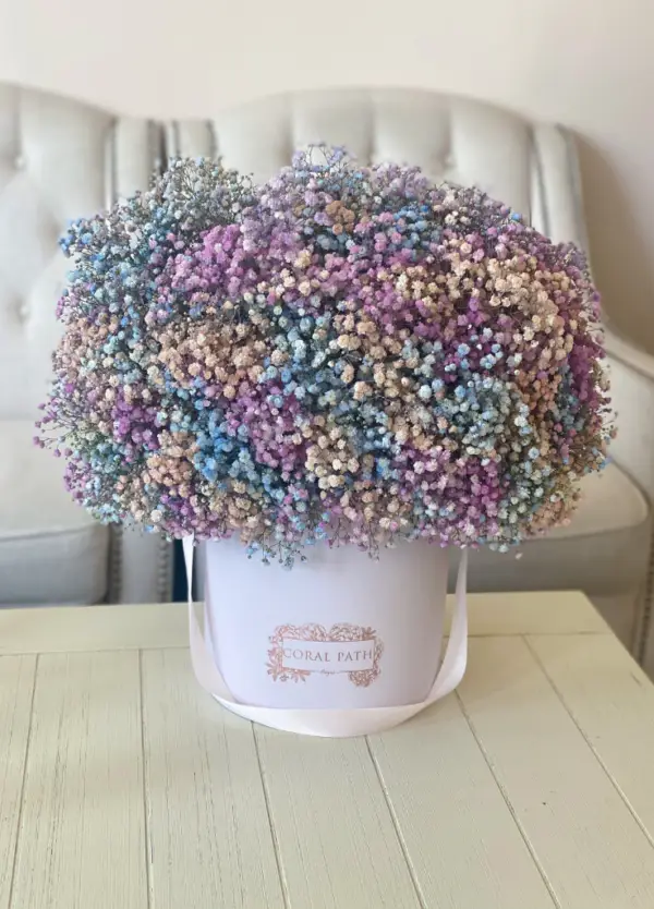 Baby's breath flowers in lavender, teal and blush pink mixed up in a hat box arrangement.
