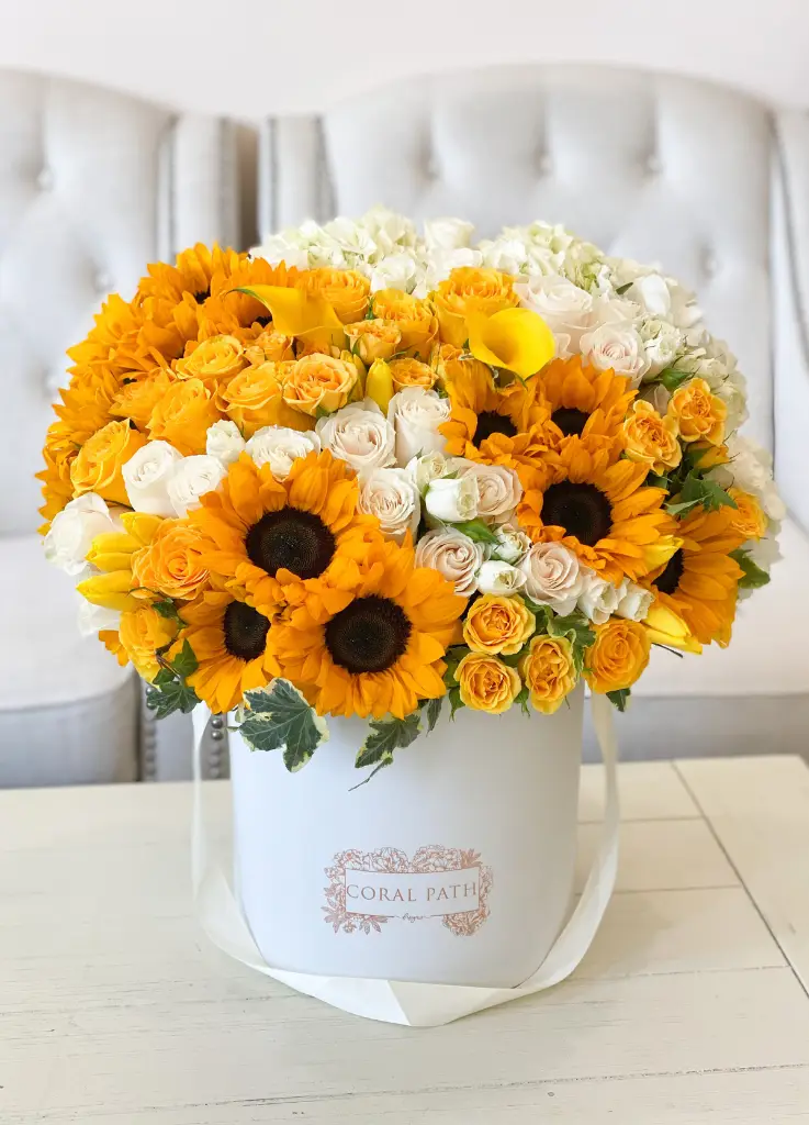 Sunny florals including yellows and whites mixed around with roses, spray roses, seasonal blooms, and super fun sunflowers!
