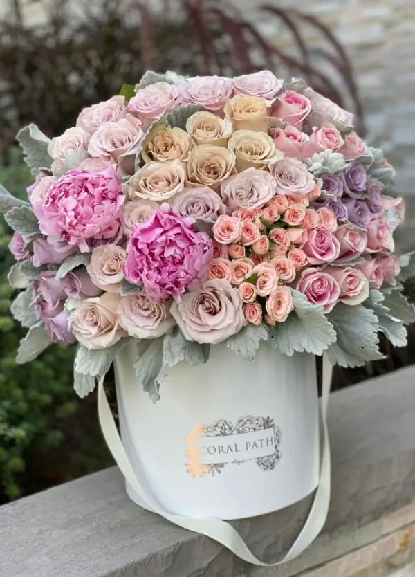 Quicksand roses, lavender and pink roses, peonies and dusty miller in a white hat box.