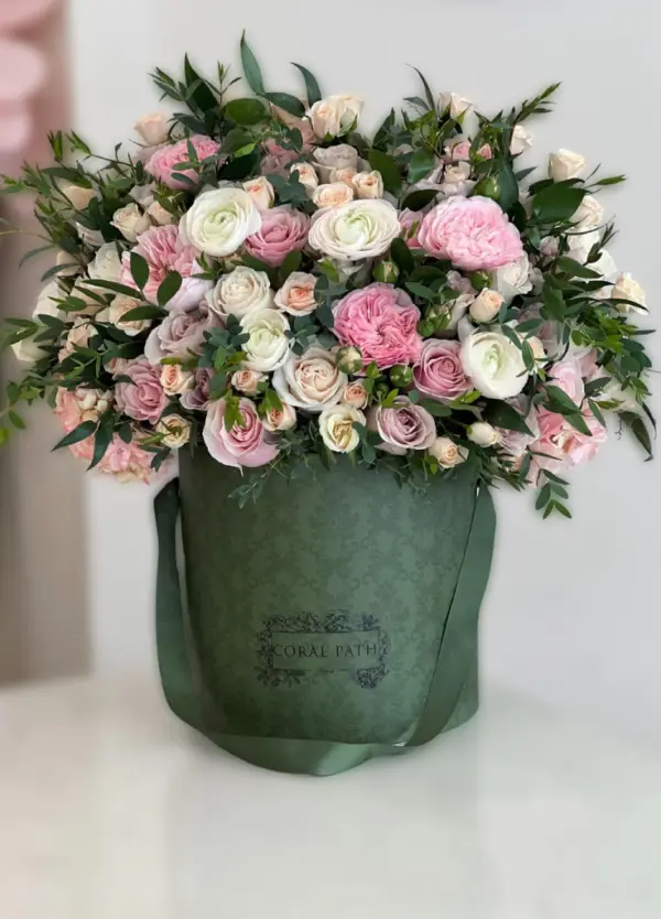 Floral bouquet of pink ranunculus and garden roses with eucalyptus. Hat box.