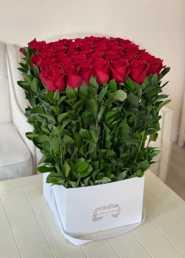 Long stem red roses arranged in a square box.