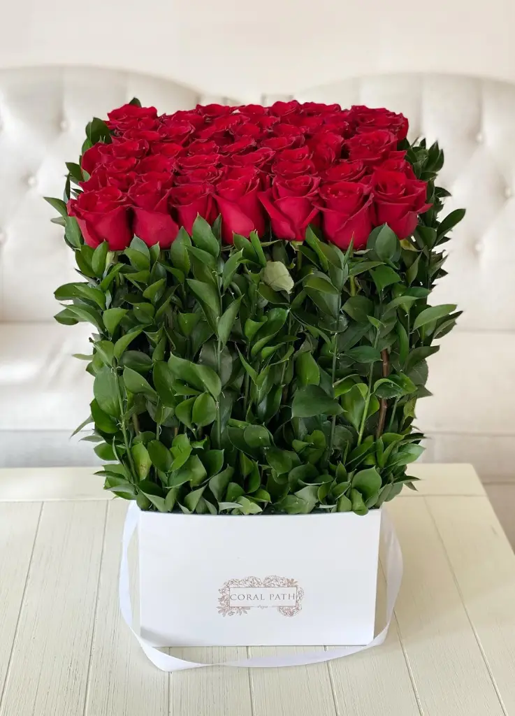 Long stem red roses arranged in a square box.
