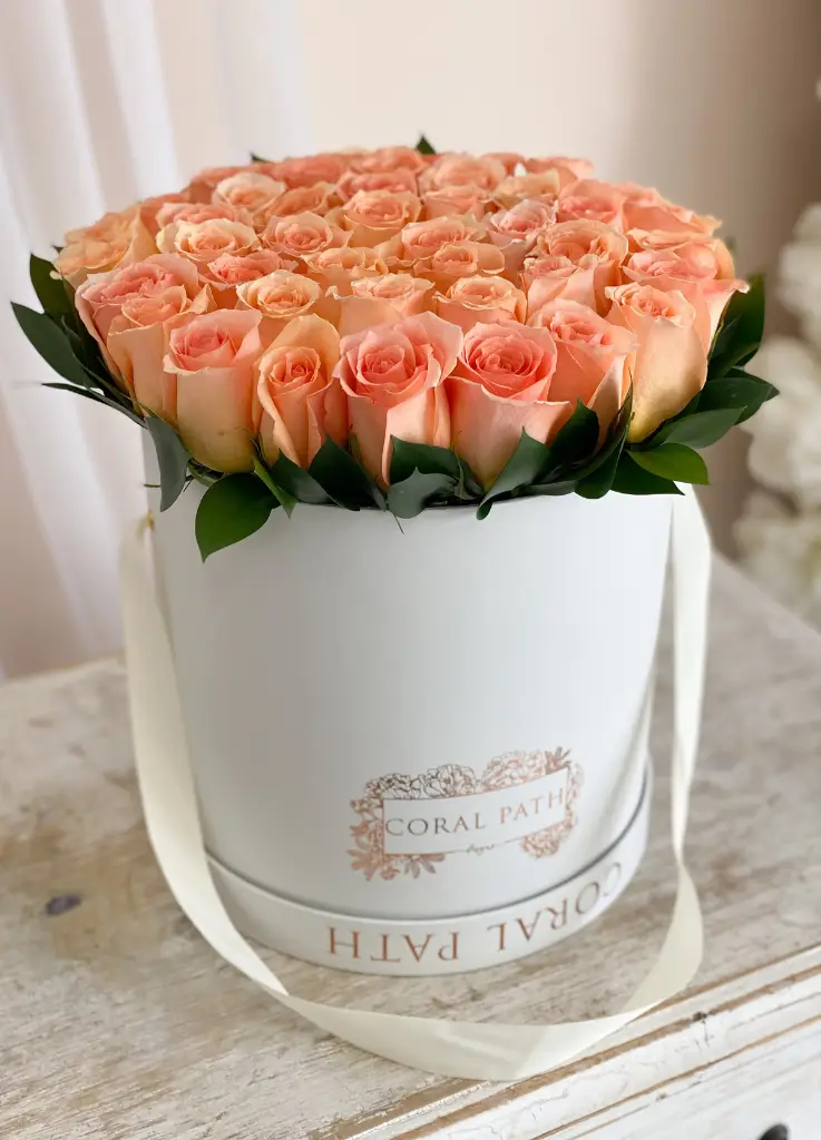 Peach Roses arranged in a hat box.