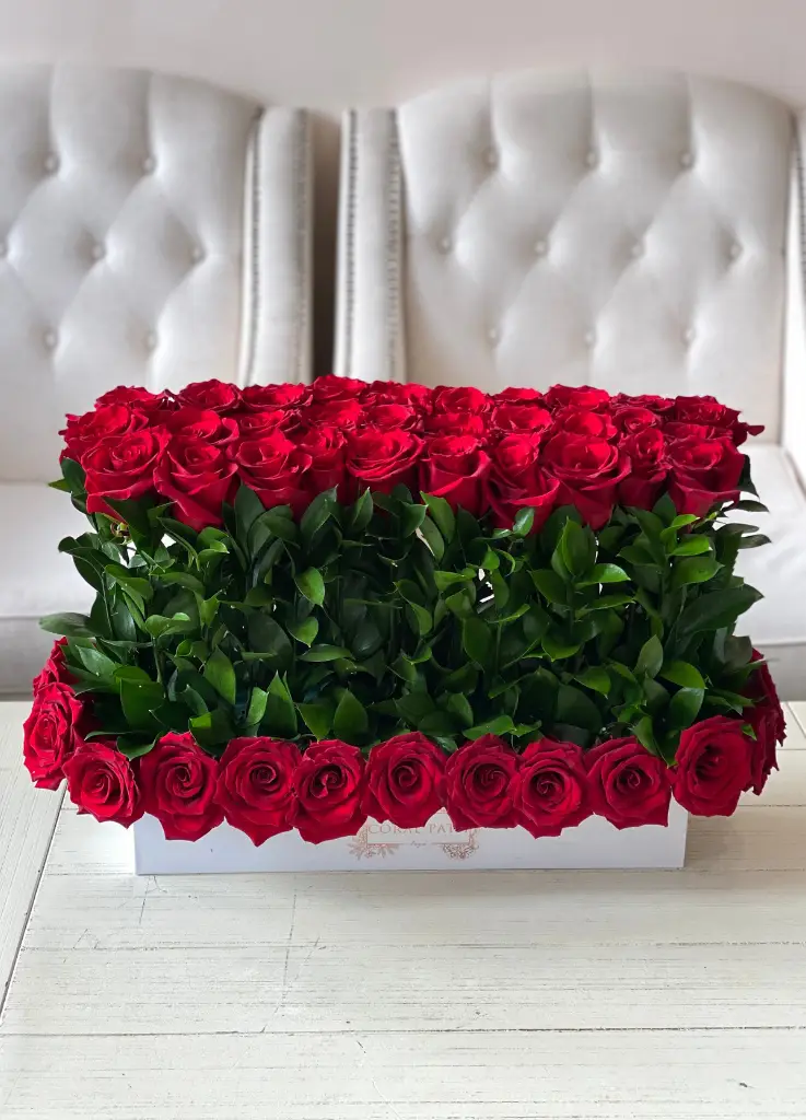 Red roses arranged in a long box.