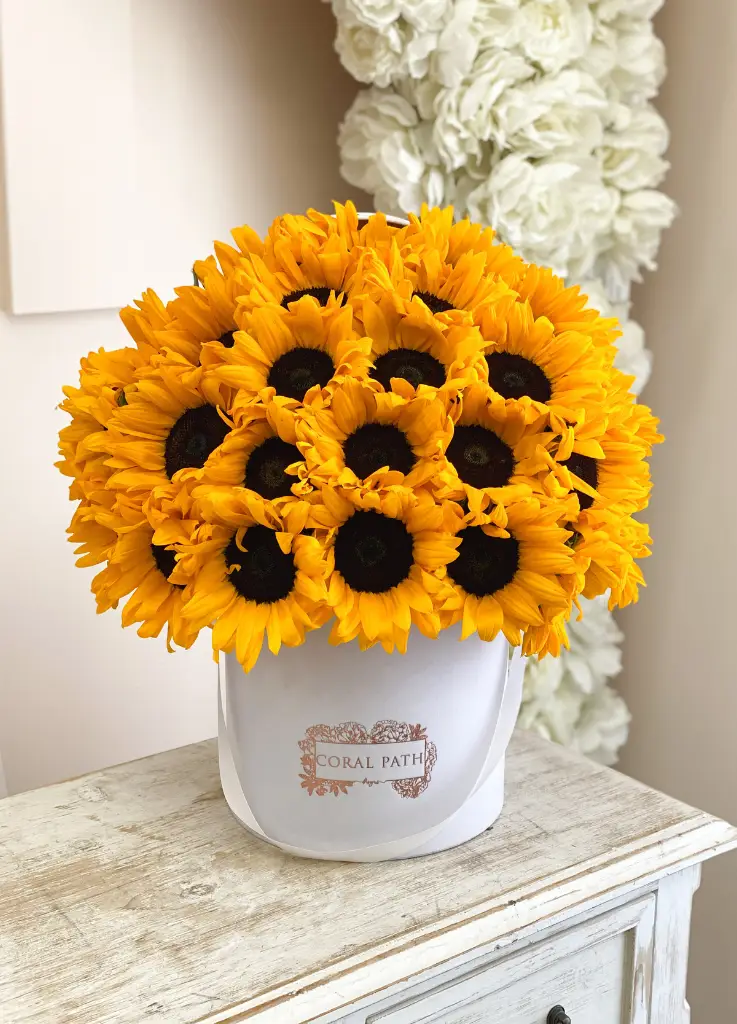 Sunflowers arranged in a hat box.