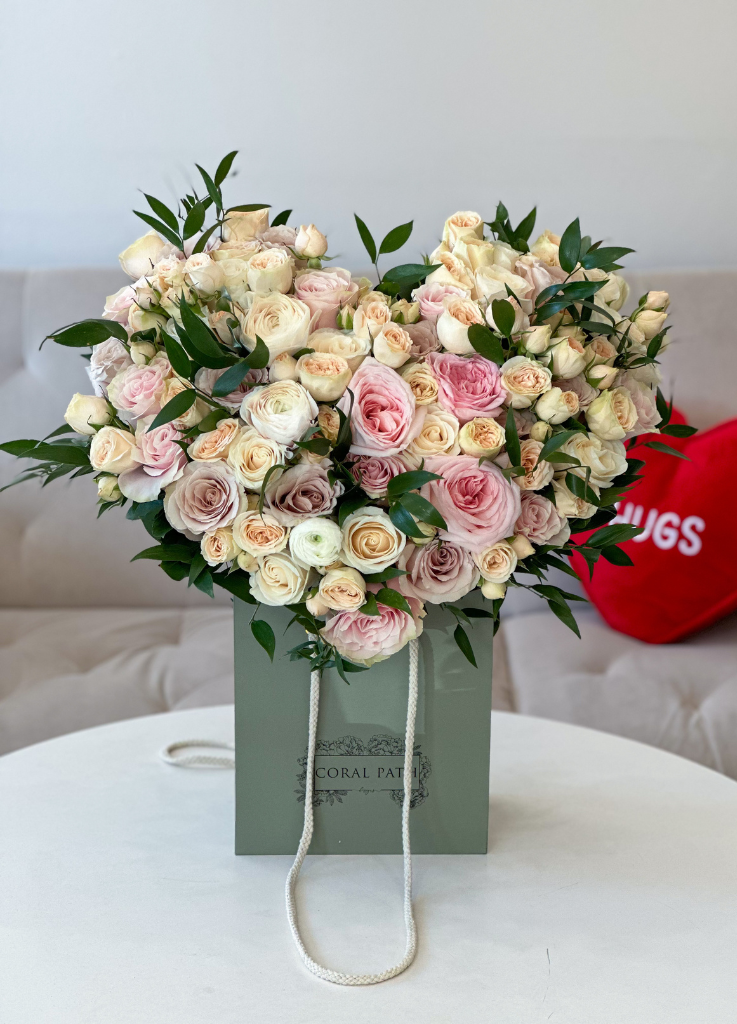 flower arrangement shaped like a heart with garden roses, roses, ranunculus and more.
