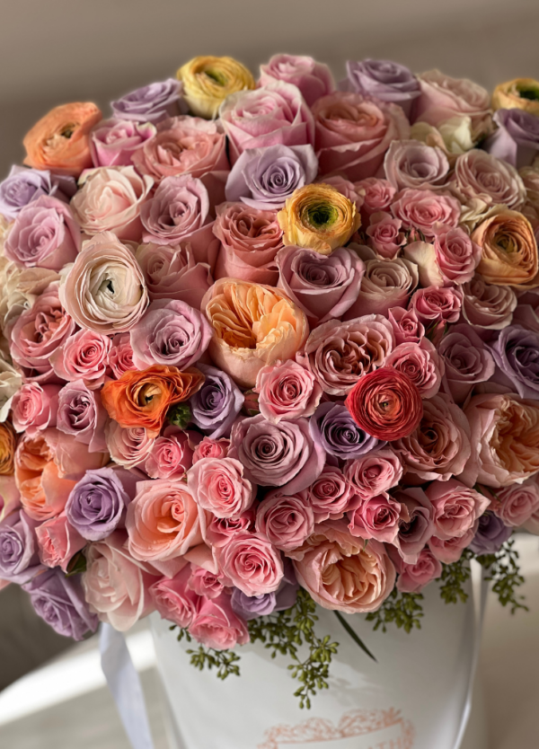 grand flower arrangement with peach, lavender and light pink pastel roses, ranunculus and more