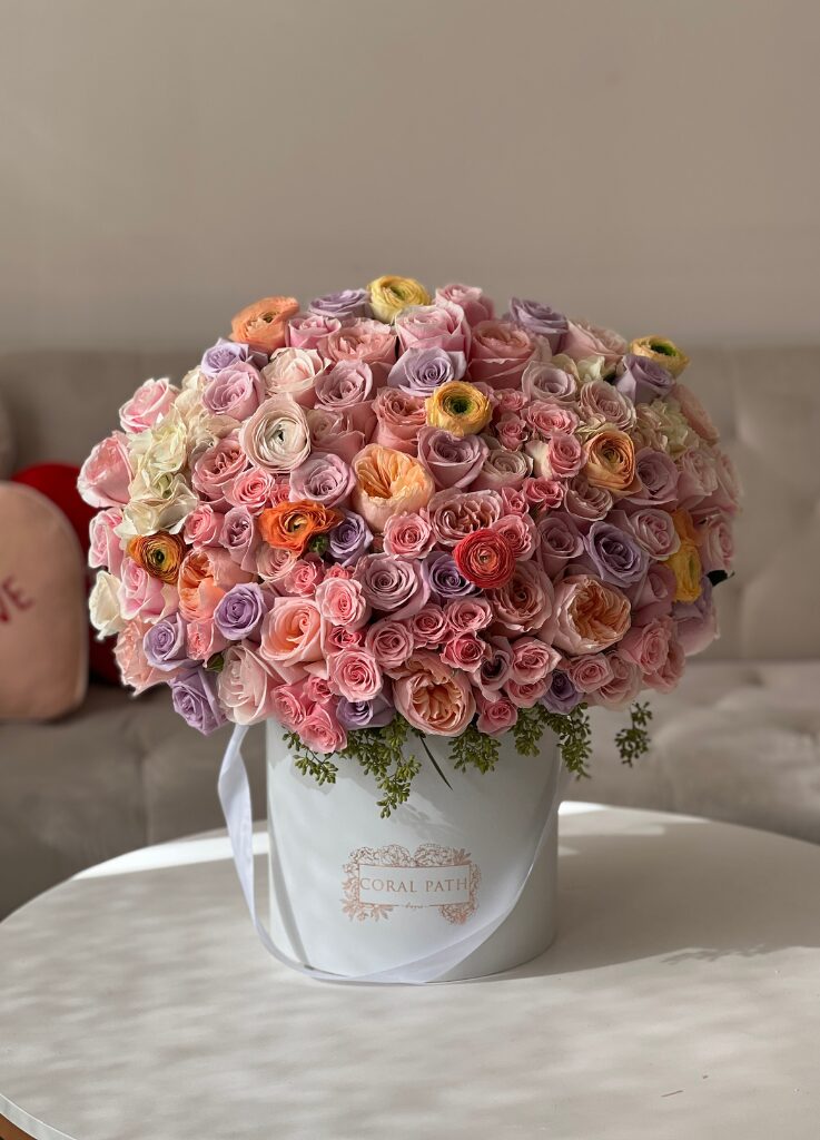 grand flower arrangement with peach, lavender and light pink pastel roses, ranunculus and more