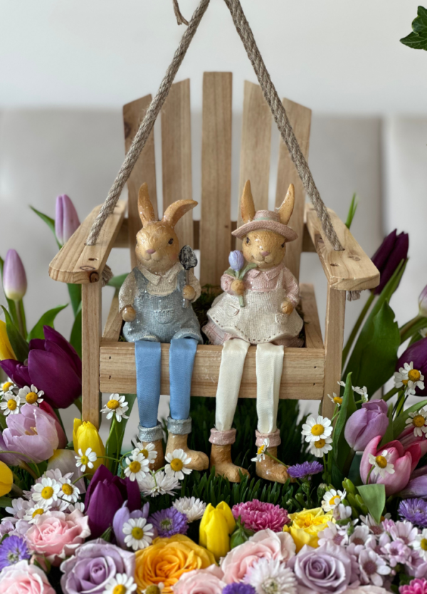 Easter basket arrangement with flowers and a swing with Easter bunnies