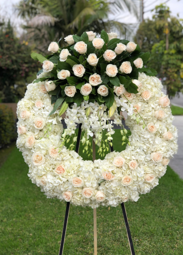 standing circle sympathy wreath with white roses on top and dendro orchids
