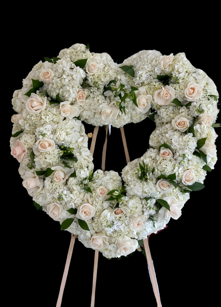 standing open heart sympathy wreath with hydrangeas roses and greenery on an easel