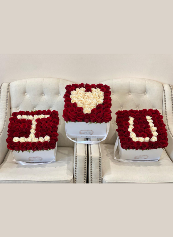 three flower boxes put together to spell out i love you with red and white roses