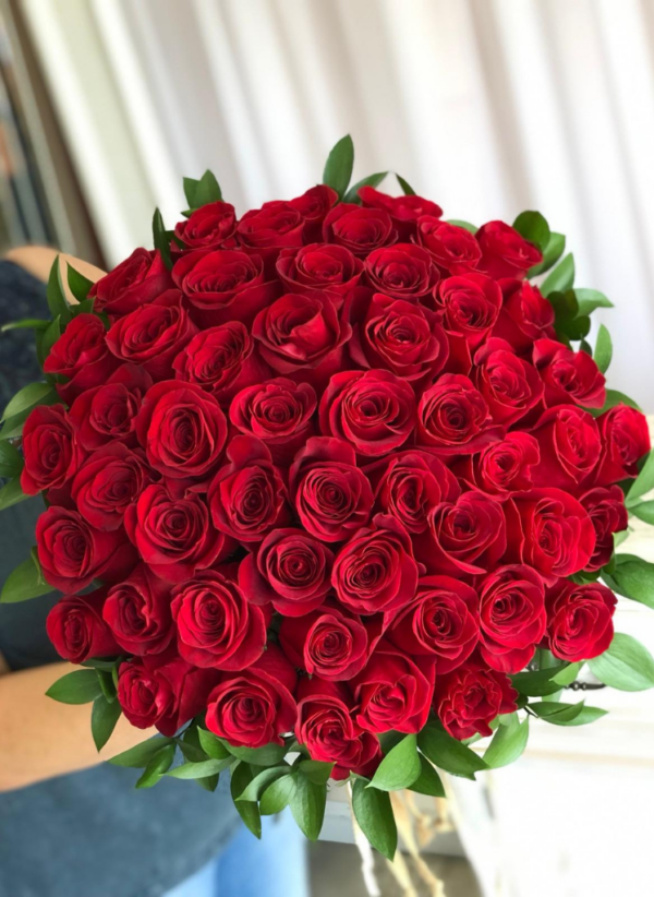 red roses tightly tied together in a bouquet