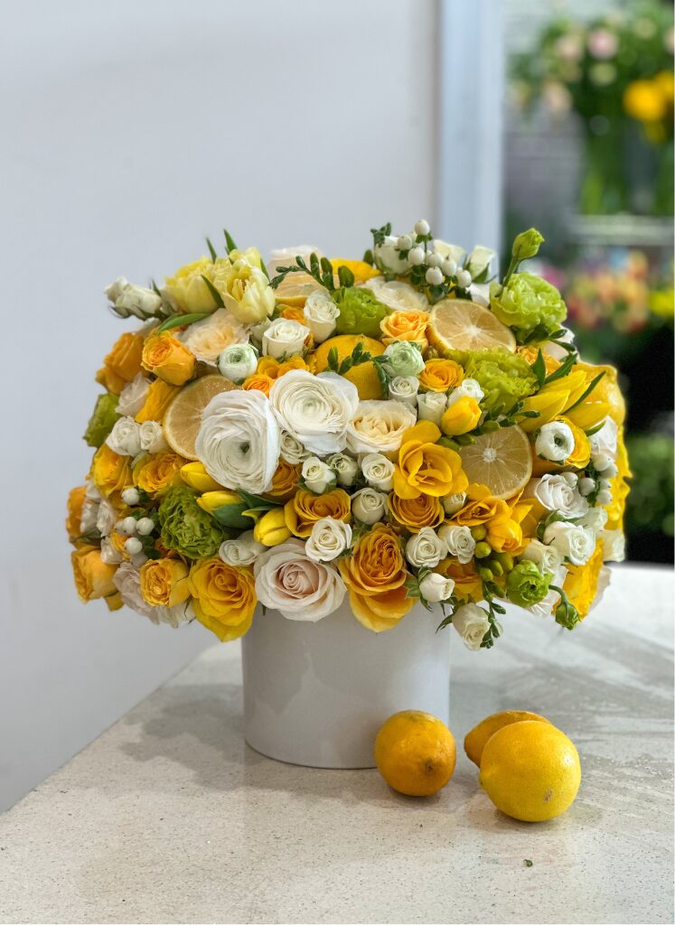 flowers in a vase with fresh lemons