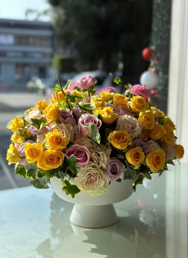 spring flowers in a white pedestal vase