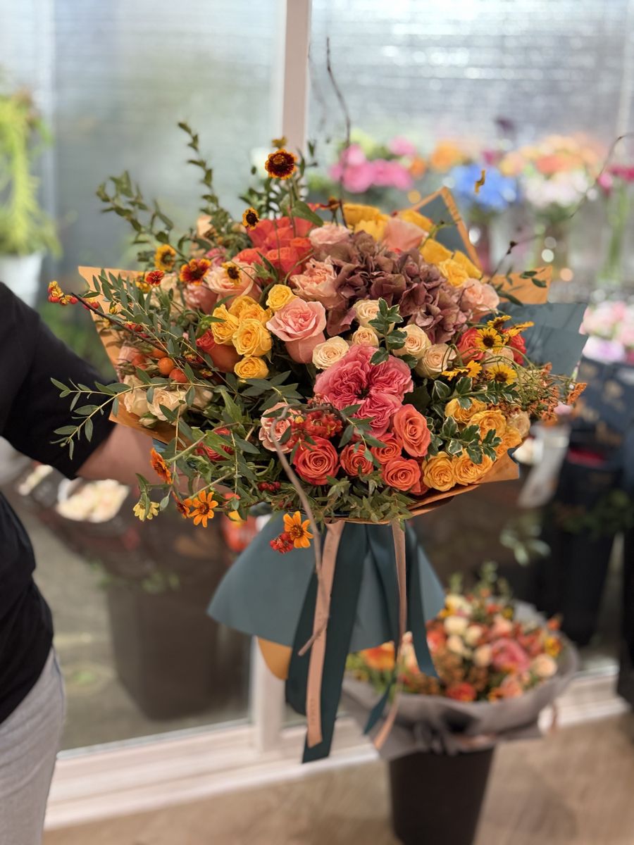 Fall Bundle hand-tied autumn bouquet with coral garden roses, golden spray roses, antique hydrangea and marigolds, wrapped in kraft paper by Coral Path Designs, Los Angeles